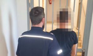 zatrzymany mężczyzna w asyście policjanta