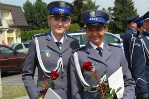 Dwie umundurowane policjantki trzymają w rekach róże.