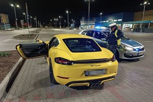 policjant kontrolujący żółte porsche