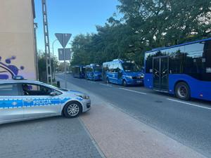 autobusy komunikacji miejskiej, w tle radiowóz policyjny oznakowany