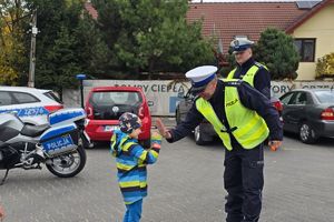 dziecko przybija piątkę z policjantem