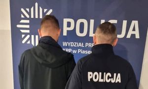 umundurowany policjant z zatrzymanym mężczyzną