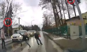 stopklatka z nagrania, kobieta oraz dzieci znajdujące się na przejściu dla pieszych w trakcie nadawania czerwonego sygnału na ich sygnalizatorze