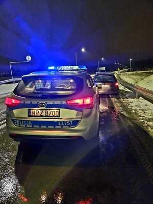 auto zatrzymane do kontroli drogowej, w tle radiowóz