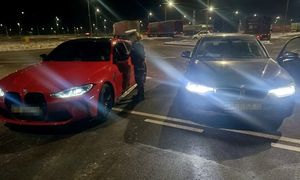 kontrola drogowa, czerwone BMW i stojąca obok niego umundurowana policjantka wydziału ruchu drogowego