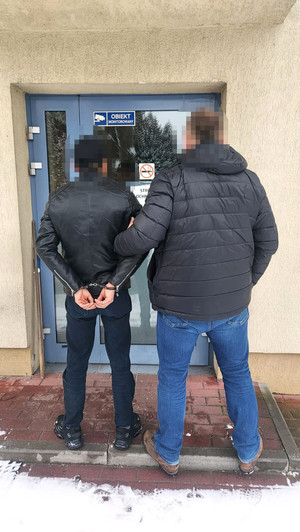 zatrzymany mężczyzna w asyście policjanta