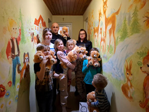 dzieci z policjantami oraz maskotkami które otrzymały w trakcie spotkania