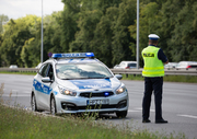 policjant stojący przy radiowozie