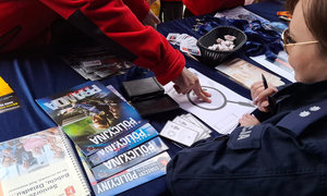 policjanci w trakcie pikniku rodzinnego, dzieci wykonują odciski palców