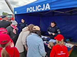 policjanci w trakcie pikniku rodzinnego, dzieci wykonują odciski palców