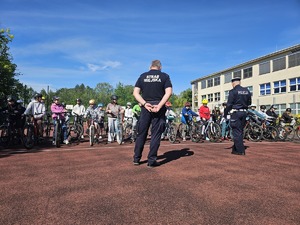 policjant i strażnik miejski, przed nimi dzieci