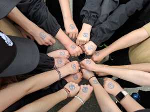 uczestnik pikniku siedzący w radiowozie i trzymający ulotkę zachęcającą do wstąpienia w szeregi policji