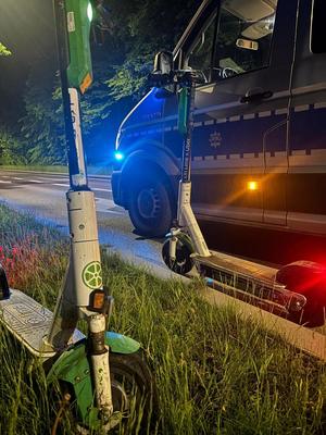 hulajnoga elektryczna, w tle policyjny radiowóz