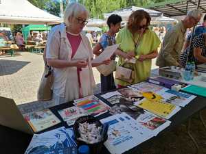 seniorzy trzymający ulotki informacyjne, które otrzymali w trakcie spotkania