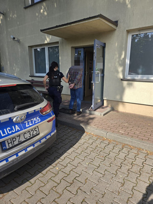 zatrzymany mężczyzna wprowadzany do siedziby jednostki lesznowolskiej policji