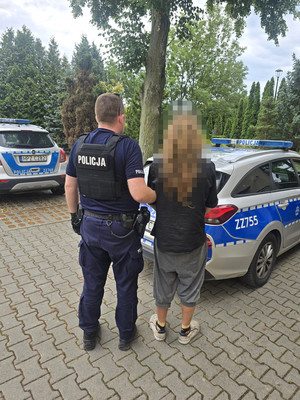 zatrzymany mężczyzna w asyście policjanta