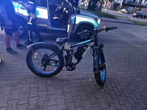 policyjny radiowóz oraz rower zatrzymany do kontroli drogowej