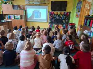 przedszkolaki w trakcie spotkania, siedzące na krzesełkach i oglądające bajkę o bezpieczeństwie