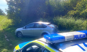 policyjny radiowóz i auto stojące obok zarośli przy wale wiślanym