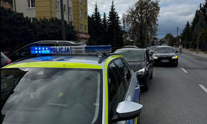 auto marki Opel zatrzymane do kontroli drogowej, przed nim stojący radiowóz