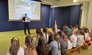 policjantka pokazująca dzieciom znaki drogowe