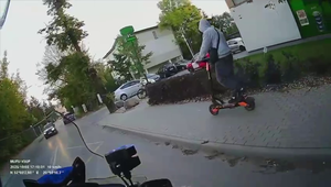 mężczyzna na hulajnodze jadący chodnikiem