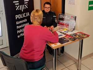 policjantka przekazująca kobiecie ulotki informacyjne