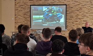 uczniowie siedzą, policjanci omawiają przygotowaną prezentację