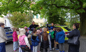 policjanci wraz z dziećmi, w tle policyjne radiowozy