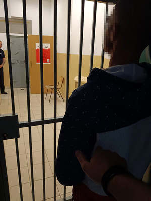 zatrzymany mężczyzna stojący przed wejściem dla osób zatrzymanych