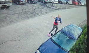 mężczyzna z młotkiem w ręku, niszczy auto