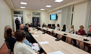 zdjęcie wykonane w trakcie debaty, mieszkańcy siedzą przy stole