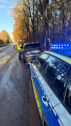 auto zatrzymane do kontroli drogowej, w tle policyjny radiowóz