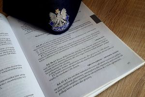 kodeks wykroczeń otwarty na stronie z art. 66 kw. na kodeksie leży czapka policyjna