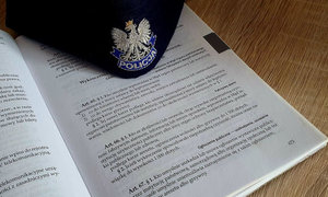 kodeks wykroczeń otwarty na stronie z art. 66 kw. na kodeksie leży czapka policyjna