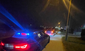 auto zatrzymane do kontroli drogowej, w tle policyjny radiowóz