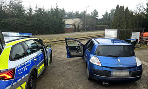 niebieskie auto zatrzymane do kontroli, a obok niego stojący policyjny, oznakowany radiowóz