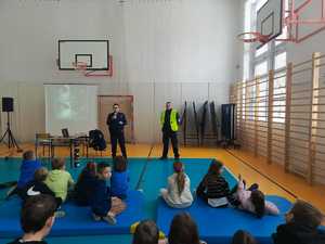 umundurowana policjantka w trakcie prelekcji, dzieci siedzą przed nią