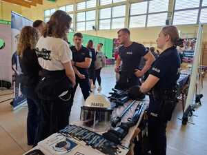 na zdjęciach widać policjantów i ich stanowisko promocyjne, a także młodzież, która rozmawia z policjantami, otrzymuje ulotki informacyjne