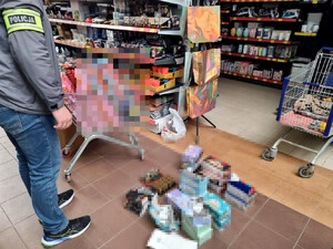 policjant z opaską z napisem Policja oraz zabezpieczone przedmioty