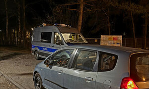 auto zatrzymane do kontroli drogowej, w tle policyjny oznakowany radiowóz