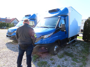 nieumundurowany policjant, w tle odnalezione auta