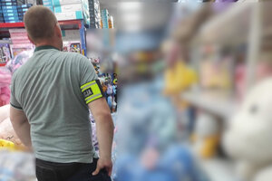 policjant z naramiennikiem z napisem Policja, obok zabezpieczone zabawki