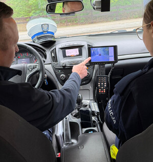 policjanci piaseczyńskiego wydziału ruchu drogowego w trakcie wspólnych służb z kursantami z Centrum Szkolenia Policji w Legionowie. Funkcjonariusze kontrolują zatrzymane do kontroli auto jak również wskazują obsługę urządzenia pomiarowego