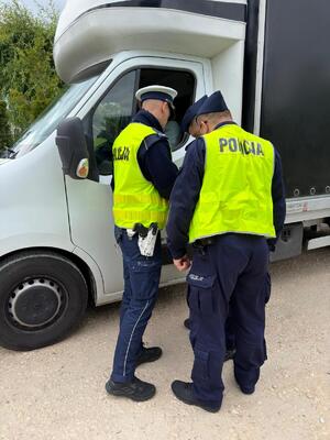 policjanci piaseczyńskiego wydziału ruchu drogowego w trakcie wspólnych służb z kursantami z Centrum Szkolenia Policji w Legionowie. Funkcjonariusze kontrolują zatrzymane do kontroli auto jak również wskazują obsługę urządzenia pomiarowego