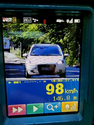 zdjęcie z przekroczeniem prędkości, na zdjęciu widoczne jest auto marki Fiat koloru białego, a także prędkość 98 km/h