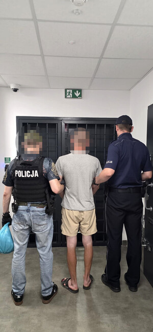 zatrzymany mężczyzna w asyście dwóch policjantów