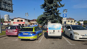 policyjny radiowóz, obok auto zatrzymane do kontroli drogowej