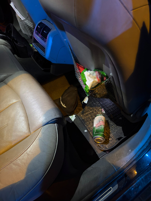 Wnętrze auta. Na wycieraczce tylnego pasażera leży puszka po alkoholu.