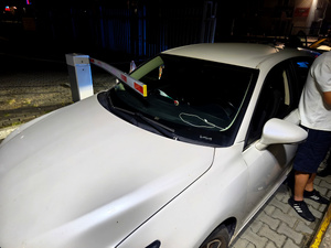 białe auto i uszkodzony szlaban